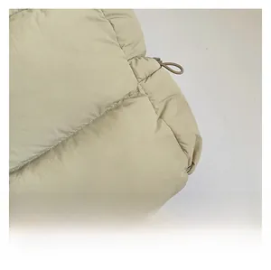 Detail shot of beige quilted fabric texture with drawstring components on the shoulder bag