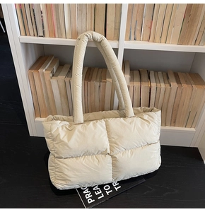 Close-up of beige quilted puffer tote bag with soft padded texture and spacious design