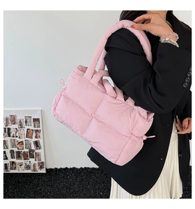 Pink quilted tote bag with soft padded texture and woven pattern on female model