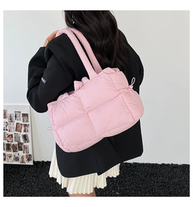 Detail view of pink quilted tote bag with soft padded texture and wide shoulder strap