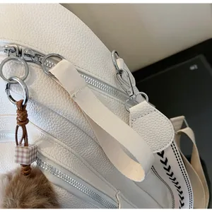 Detail of white lychee texture leather backpack with premium silver metal zipper