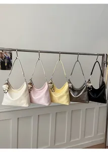 Close-up of pleated PU leather tote bags in various colors with white fuzzy pompom charms