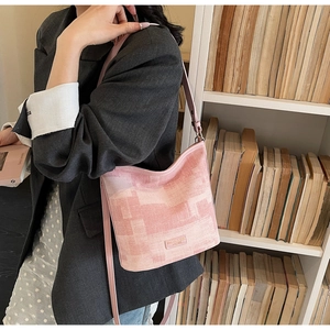 Vista dettagliata della borsa a secchiello rosa sfumata con tracolla in stile lifestyle