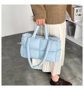 Close-up of light blue quilted puffer tote bag with soft texture and drawstring detail
