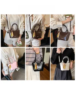 Detailansicht bunter glänzender Ledertaschen mit runden Griffen und Perlenquasten