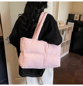 Detail of pink puffy tote bag with diamond quilted pattern and padded shoulder straps