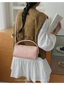 Rosafarbene Zylindertasche kombiniert mit brauner Weste und weißem Faltenrock