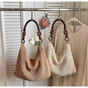 Detail of hand-woven crochet tote bag featuring decorative wooden bead ring handles