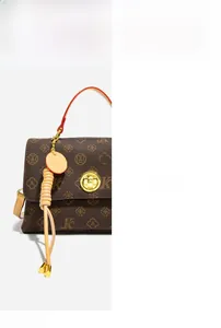 Close-up of golden hardware lock and exquisite woven tassel on vintage crossbody bag