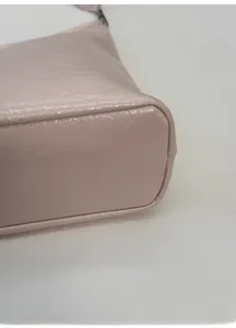 Close-up of a wide reinforced base on a textured faux leather tote bag with fine stitching
