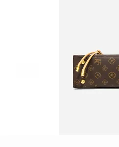 Close-up of vintage monogram pattern with gold studs and drawstring on crossbody bag