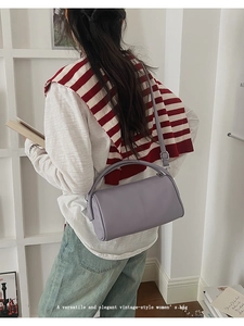 Macro view of lavender lychee texture leather handbag with adjustable shoulder strap