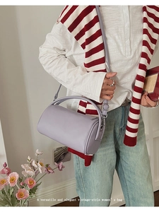 Detail der lavendelfarbenen Zylindertasche mit Ledertextur und elegantem Handgriff