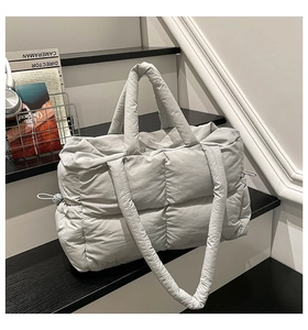 Detail view of light grey quilted puffer tote bag with side drawstring and double straps