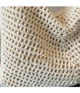 Detailed macro shot of beige hollow diamond knit pattern and cotton lining on tote bag
