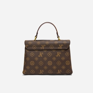 Close-up of vintage brown leather handbag with monogram pattern and gold metal hardware