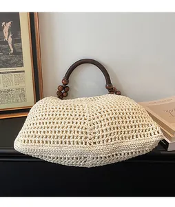 Detail of woven beach tote with round dark wood handles and decorative beads