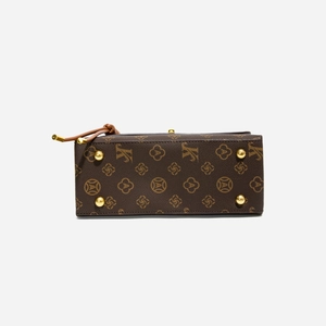 Detail of purse base with four gold metal feet and vintage monogram floral pattern