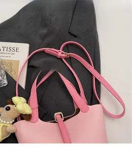 Detail of pink lychee leather bag with adjustable shoulder strap and gold hardware