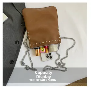 Brown rivet chain bag showing interior capacity with phone, lipsticks and a folded umbrella