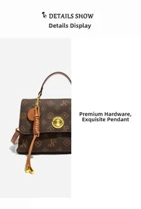 Detail of vintage patterned crossbody bag showing golden metal hardware and woven charm