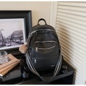 Detail of black lychee grain leather backpack with silver zippers and V-pattern strap