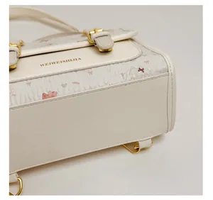 Close-up of cream PU leather bag featuring cute cartoon bear prints and gold buckle detail