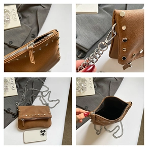 Detailed macro view of vintage brown leather bag featuring silver rivets and chain strap