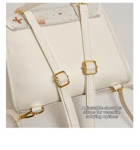 Detail of adjustable leather shoulder straps with golden metal buckles on a white backpack