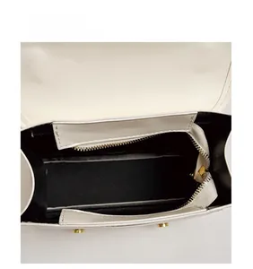 Vertical view of white leather backpack interior with black lining and gold zipper pocket