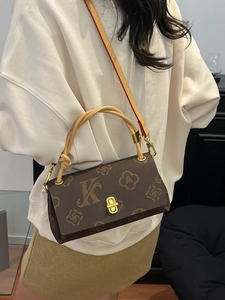 Klassische braune Monogramm-Umhängetasche mit goldener Hardware in einer Lifestyle-Szene