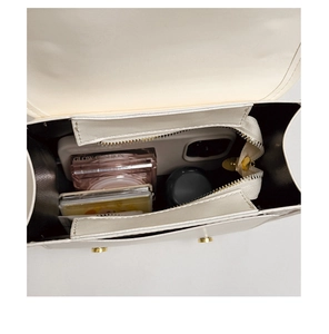 Interior view of cream PU leather handbag showing storage space for phone and makeup