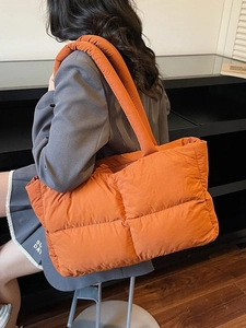 Bright orange large quilted puffer tote bag with waterproof nylon finish and twin straps