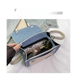 Detail of blue denim crossbody bag with interior storage for phone and cosmetics