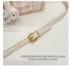 Detail of adjustable leather strap with gold buckle and cute rabbit plush charm