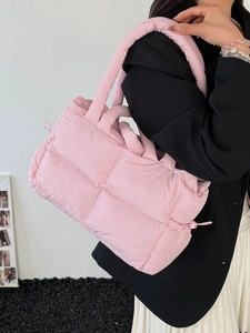 Pink quilted puffer handbag with woven texture shown as stylish tote and shoulder bag