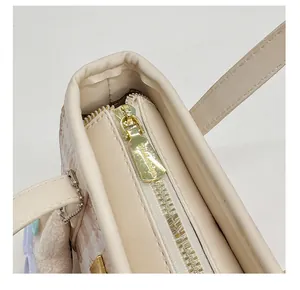 Detail of high-quality gold zipper on beige bucket bag with cute plush charm