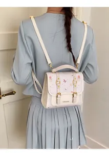 Detail of cute cream college backpack with pink bear patterns shown on a model