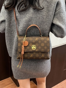 Retro vintage brown monogram crossbody bag with golden buckle shown on a model