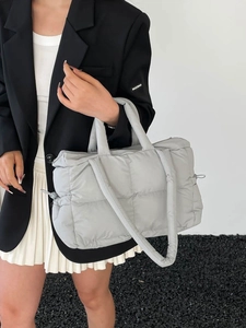Quilted nylon grey tote bag with soft texture and wide shoulder strap shown on model