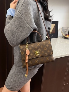 Classic brown vintage monogram crossbody bag with flap and metal lock on a model