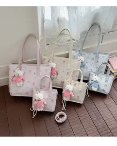 Detail of cartoon print tote bags with cute bear charms in pink, white, and blue colors