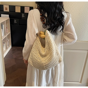 Detail of hand-woven beige crochet tote bag with wooden bead strap in a boho style