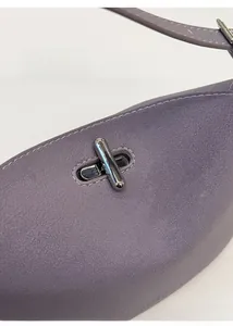 Dettaglio della pelle lavanda e della chiusura a scatto in argento sulla borsa