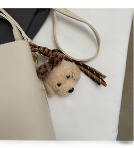 Dettaglio di un ciondolo a forma di orsetto di peluche con fiocco leopardato