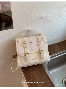 Detail of cream multi-functional backpack with pink cartoon cat patterns and gold buckles