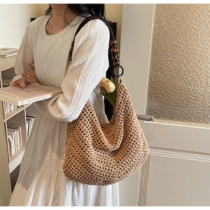 Detail of woven khaki tote bag featuring unique dark brown wooden bead shoulder straps