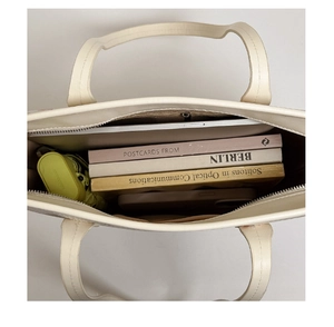 Top view of cream tote bag interior showing large capacity for books and tablet
