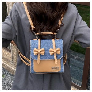 Détail d'un sac à dos en denim et cuir avec des nœuds décoratifs porté au dos