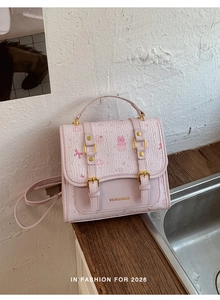 Detailed macro view of pink textured mini backpack with cute cartoon print and gold buckles